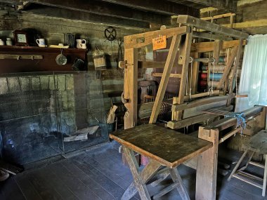 1800 'lerin dokumacı dükkanında şömine, masa ve dokumacı tezgahı var. Mitchell, Indiana yakınlarındaki Spring Mill State Park' taki Pioneer Village 'da..