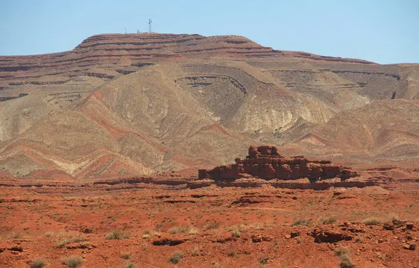 Meksika Şapkası yakınlarındaki Anıt Vadisi 'nde uzanan dağlar, Güney Utah' ta, ABD 'de, San Juan' da, Navajo Milletleri sınırlarında, mavi gökyüzü ve kayalık kopya uzayı ile kırmızı kaya oluşumu.. 