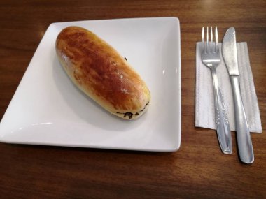 Çatal ve bıçaklı bir sandviçin mutfak fotoğrafı.