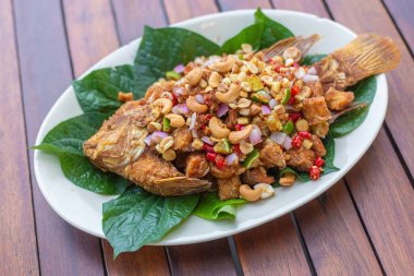 Miang Fried Red Tilapia, Tayland 'da bulunan bir yemektir: Red Tilapia, Lime, Cashew Nuts, Shallots, Chili ve Betel Leaves.