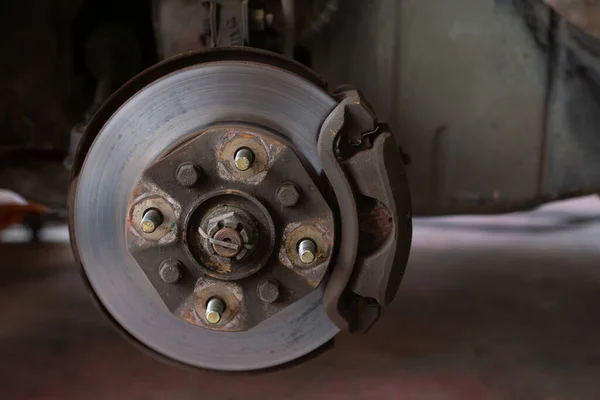 Brake discs, brake calipers and brake systems being maintained by a mechanic at a service center. Suspension of car for maintenance brakes and shock absorber systems.Close up.