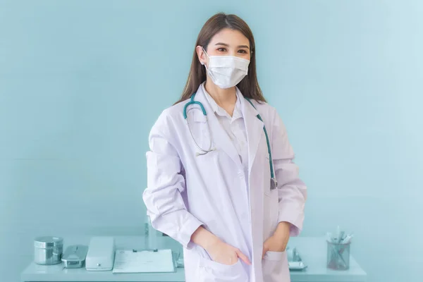 マスクと聴診器を身に着けて白いローブを着てスリで立っているプロの若いアジアの女性医師 コロナウイルスの保護は病気や健康の概念を防ぐ — ストック写真