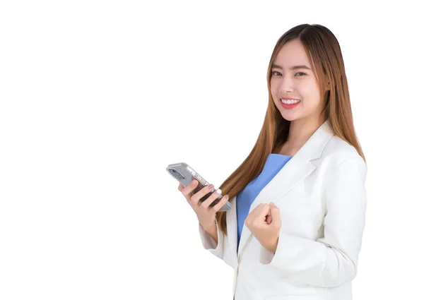 身穿白衣的漂亮职业亚洲女商人看着摄像机 手里拿着白色背景的智能手机 笑得很开心 — 图库照片
