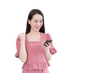 Pembe elbiseli profesyonel genç Asyalı güzel kadın mutlu bir şekilde gülümserken beyaz arka planda tek başına akıllı telefonu tutuyor...