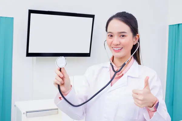 身穿医疗制服 手持听诊器的亚洲女专业医生在医院的诊疗室里举手表决 — 图库照片