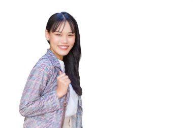 Confident professional young Asian business woman who wears a brown striped blazer and shoulder bag smiles happily and looks at the camera as she commute to work through the old town.