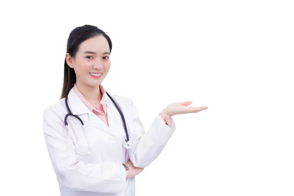 プロの若いアジアの女性医師は 白い背景で孤立しながら 病院で働いている間 カメラを見ながら何かを提示するために彼女の手を示しています — ストック写真