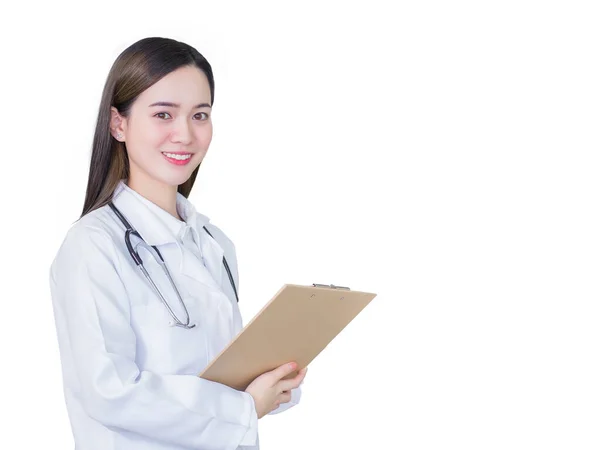 専門の美しい美しい若いアジアの女性の医者は白い背景で隔離された働いている間彼女が病院で白い実験室のコートおよびステスコープを身に着けている間カメラを見ているクリップボードの笑顔の文書を保持します — ストック写真