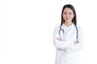Genç Asyalı profesyonel kadın doktor, beyaz cübbe ve steteskop giyerek güvenle ayakta duruyor. Hastanedeki muayene odasında, izole edilmiş beyaz arka planda..