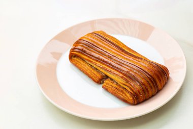 Acı au suisse hamur tatlısı çay, kahve ve kakao gibi içeceklerle yemek için uygun bir hamur işidir. Yuvarlak bir tabakta çıtır çıtır bir dışı olan lezzetli bir kahvaltı..