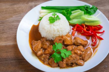 Çin usulü susam yağlı tavuk sosu ve yanında soğan, salatalık, kişniş, ahşap bir tabakta kırmızı biber ile birlikte buharda pişirilmiş yasemin pilavı..