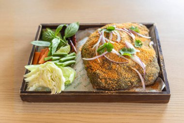 Kavrulmuş pirinç balığı sosuyla hazırlanmış domuz pirzolası ve limon serpiştirilmiş kırmızı biber..