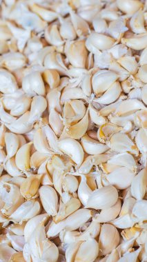 Beyaz sarımsaklı et, market masasında taze sarımsak. Yakın plan fotoğraf. Vitaminler, sağlıklı yiyecekler, baharatlar. Baharatlı yemek malzemeleri, bir yığın beyaz sarımsak karanfili, beyaz sarımsak karanfili, yığın başı, üst manzara..