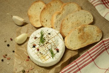 Fırında kamembert peyniri ve fırın kağıdında baharat. Kırsal bir masada ev yapımı kızarmış peynir. pankart, menü, metin yeri, üst görünüm