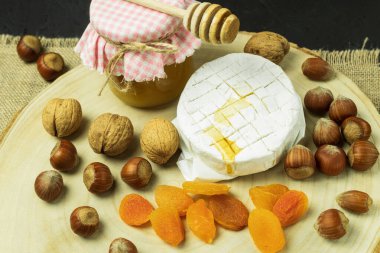 Camembert peynirinin üzerine bir damla bal damlıyor. Bal yavaşça akar ve kaşıktan damlar. Yakın plan. Boşluğu kopyala