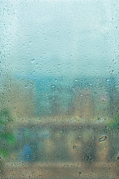雨の間にガラスに雨が降り 大きな滴 家の窓に雨滴が降る風景 青い水平線の景色 マクロ写真 — ストック写真