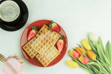 Taze laleler ve Belçika meyveli waffle 'ları. Lezzetli bir kahvaltı. Sevdiğin biri için kahvaltı. Tabakta ev yapımı waffle. Kopyalama alanı olan arkaplan