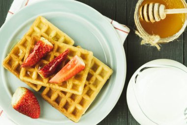 Belçika waffle 'ı ve taze meyve tabağı. Kırsal bir arka planda gri waffle. kopyalama alanı. Yukarıdan görüntüle
