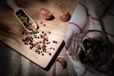Koyu ahşap bir arka planda kaşıkta baharat ve tuz. Masanın üzerinde yemek pişirmek için baharatlar var. kopyalama alanı. Nokta, yönsel ışık