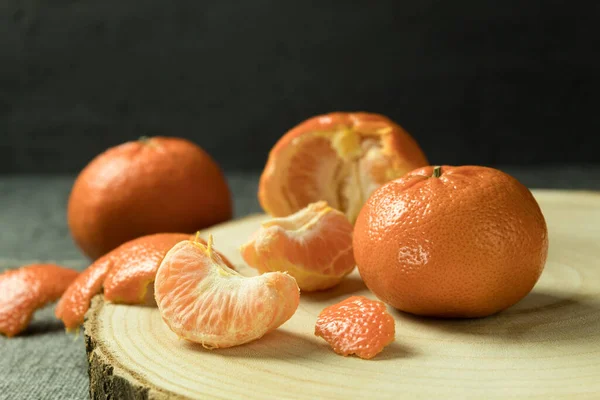 Fresh juicy orange on a wooden stand. An orange on a wooden stand on a dark background. Vitamin C. Copy space