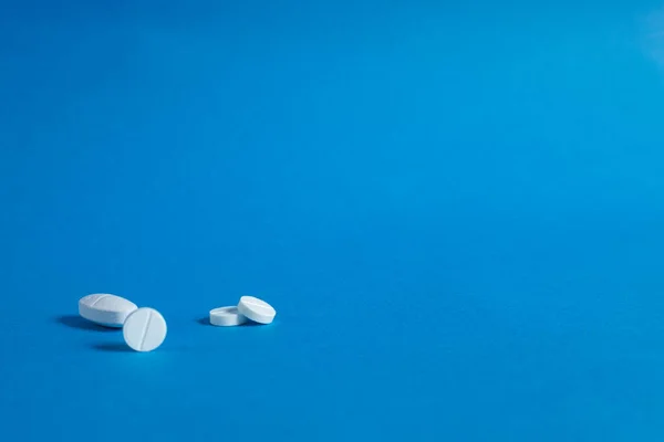 丸い白い丸薬 青の背景にクローズアップ コピースペース 医薬品の背景画像 — ストック写真