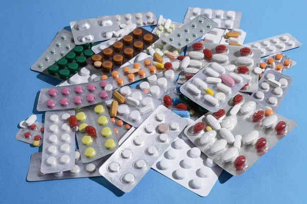 テーブルの上に散在バンドル内の丸薬の大規模な山 多色の錠剤とブリスターパックのマウンド コピースペース — ストック写真