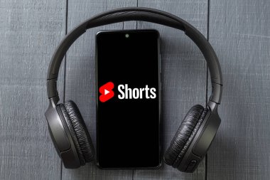 Varşova, Polonya - 14 Mayıs 2023: siyah kulaklık ve telefon. Dağın manzarası. Yakın plan. Uzayı kopyala Marka Şortlarının Metni