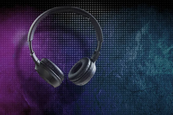 Large wireless headphones on a dark background. Black headphones, levitation. Copy space