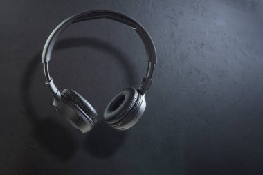 Karanlık arka planda kablosuz büyük kulaklıklar. Siyah kulaklıklar, havalanma. Boşluğu kopyala