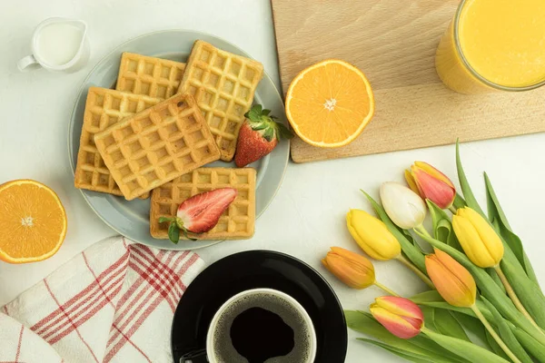 Belgian waffles for breakfast, fresh flowers and coffee. Fresh strawberries and waffles. Copy space