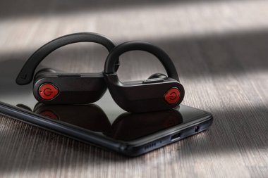 Kablosuz kulaklıklar, masada modern kulaklıklar. Kulaklık ve telefon.