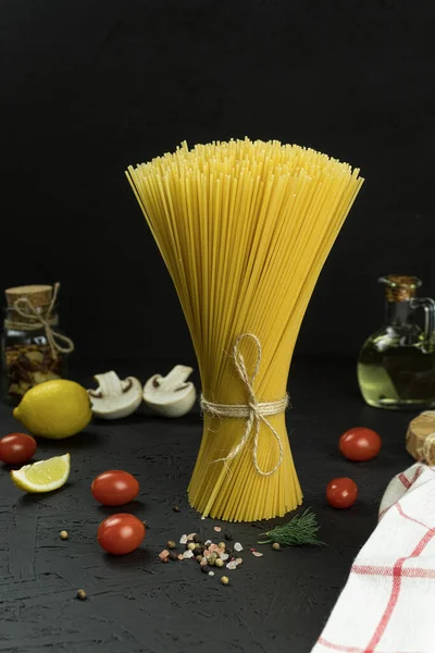 stock image Raw and fresh homemade pasta on the table, close-up. Cooking concept. Side view on a dark background. Copy space