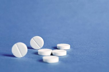 Mavi arka planda beyaz yuvarlak tıbbi haplar. Tıbbi ve ilaç tedavi konsepti. Boşluğu kopyala