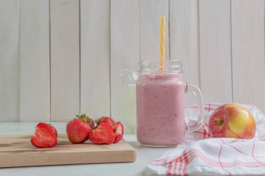 Çilekli taze milkshake. Bir bardak taze çilekli milkshake. Hafif ahşap arka planda taze çilekli püre. Sağlıklı yiyecek ve içecek konsepti