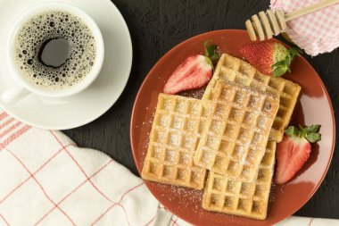 Masada taze waffle, taze pişmiş Belçika waffle 'ı. Ahşap zemin, kopyalama alanı. Lezzetli ev yapımı Belçika waffleları. Şerbetli ya da ballı. Tatlı yaz kahvaltısı.