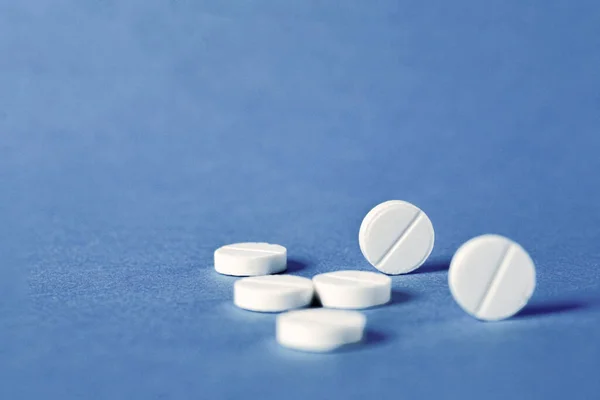 青い背景に白い丸薬 医薬品治療の概念 スペースのコピー — ストック写真