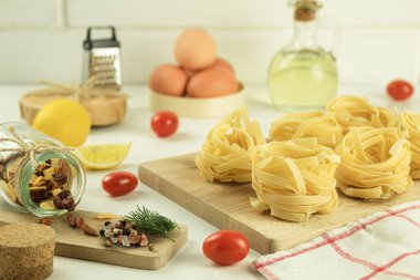 Çiğ ve taze ev yapımı makarna, masada, yakın plan. Yemek pişirme konsepti. Koyu bir arka planda yan görüş. Boşluğu kopyala