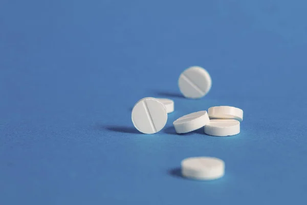 青い背景に白い丸薬 医薬品治療の概念 スペースのコピー — ストック写真