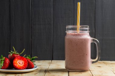 Taze çileklerden meyve püresi, koyu arkaplan. Uzayı kopyala Çilekli smoothie.