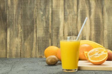 Pipetle bardakta taze portakal suyu. Kırsal arka plan. Citrus suyu.