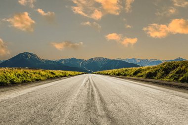 Dağlık bir bölgede bir yol. Güzel dağ manzarası. Dağlık bölgedeki otoyolun manzarası. Güzel bir arka plan. Güzel doğada yol manzarası. Gün batımı, gün doğumu