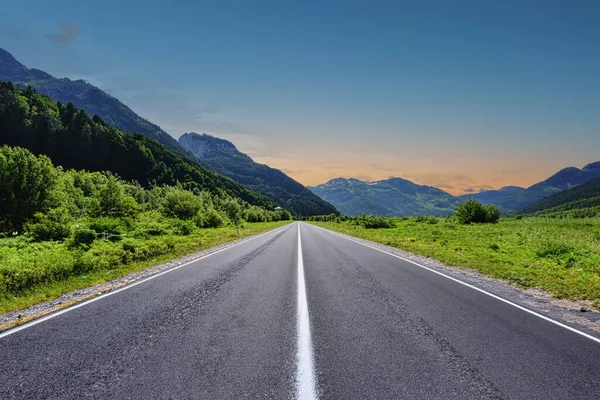 Dağlık bir bölgede bir yol. Güzel dağ manzarası. Dağlık bölgedeki otoyolun manzarası. Güzel bir arka plan. Güzel doğada yol manzarası. Gün batımı, gün doğumu