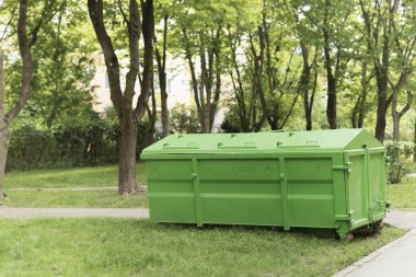 Yıkama ve inşaat atığı için büyük bir konteynır. Bahçedeki çöpler için bir çöp kutusu. Çöplerle dolu bir çöp konteynırı. Sanayi ve ev atıkları