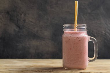 Taze çileklerden meyve püresi, koyu arkaplan. Uzayı kopyala Çilekli smoothie.