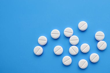 Mavi, tıbbi geçmişi olan haplar. İlaç hapı yığını. Renkli haplar ve kapsüllerle dolu bir geçmiş. Boşluğu kopyala