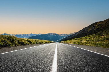 Dağlık bir bölgede bir yol. Güzel dağ manzarası. Dağlık bölgedeki otoyolun manzarası. Güzel bir arka plan. Güzel doğada yol manzarası. Gün batımı, gün doğumu
