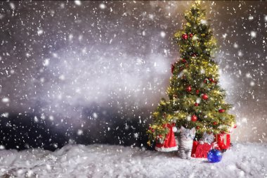 Noel Baba şapkalı şirin bir kedi yavrusu çelenkli bir Noel ağacının arka planında. Noel arkaplanı. Uzayı kopyala Yapay zeka tarafından üretilmiş.