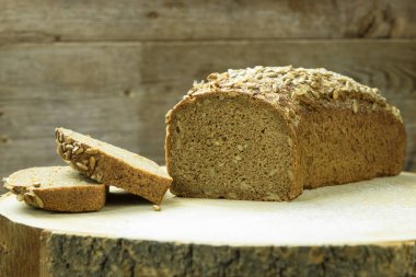 Taze siyah ekmek. Tahtada çavdar ekmeği var. Tohumlu tam tahıllı çavdar ekmeği. Sağlıklı beslenme. Boşluğu kopyala