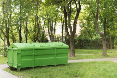 Yıkama ve inşaat atığı için büyük bir konteynır. Bahçedeki çöpler için bir çöp kutusu. Çöplerle dolu bir çöp konteynırı. Sanayi ve ev atıkları