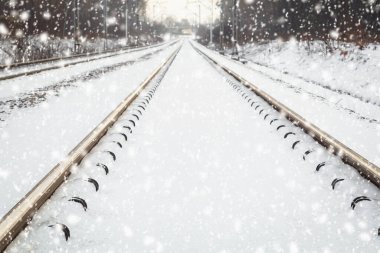 Kışın demiryolu. Ormanda kış demiryolu. Karda demiryolu. Boş tren rayları olan kış manzarası. Kar yağıyor. Yol manzarası